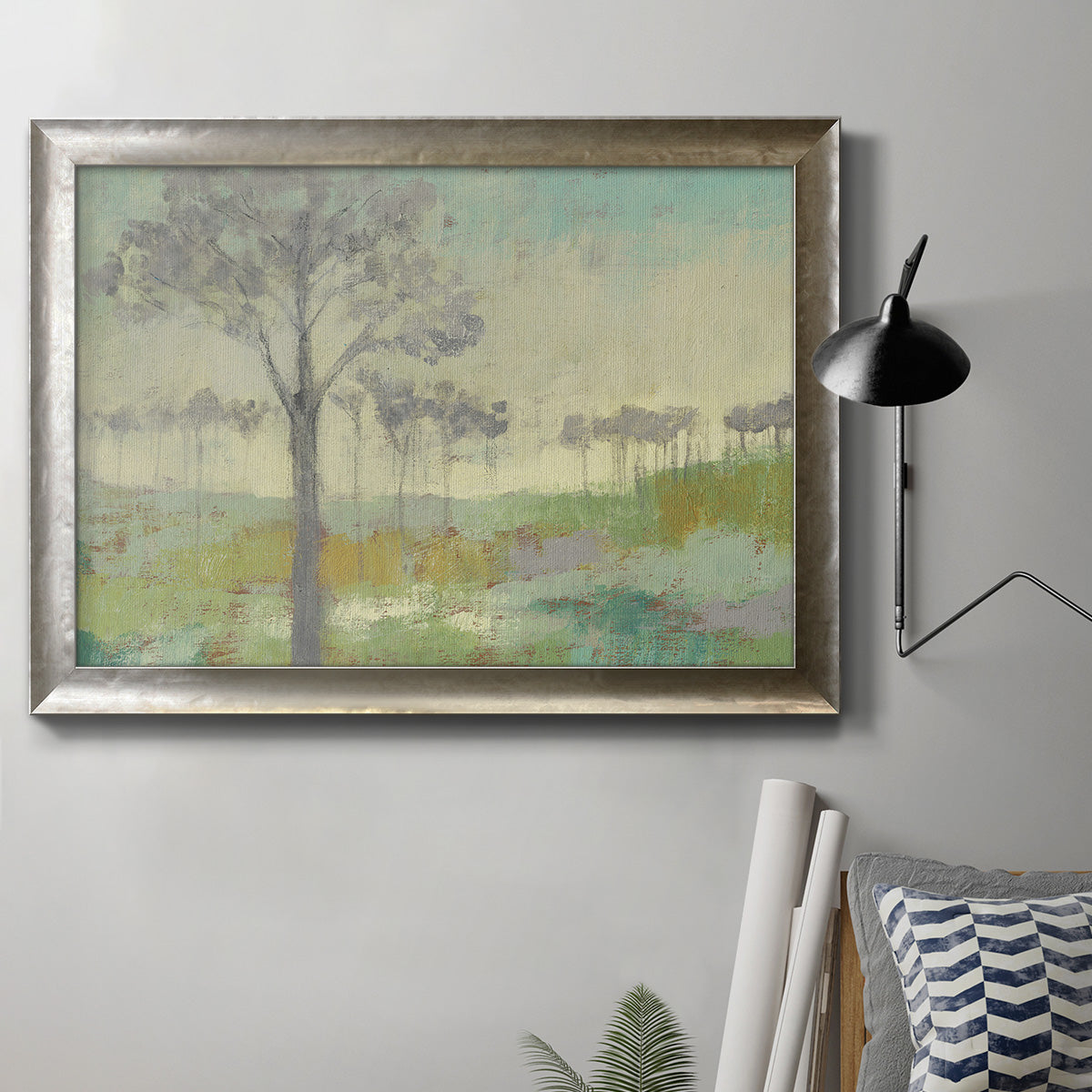 Traditional watercolor tree landscape artwork in an ornate mottled silver frame displayed in a neutral interior setting.