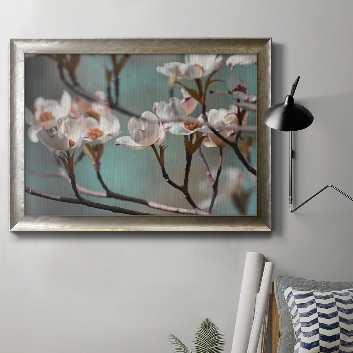 Close-up dogwood blossom photography in an ornate mottled silver frame displayed in a neutral interior setting.