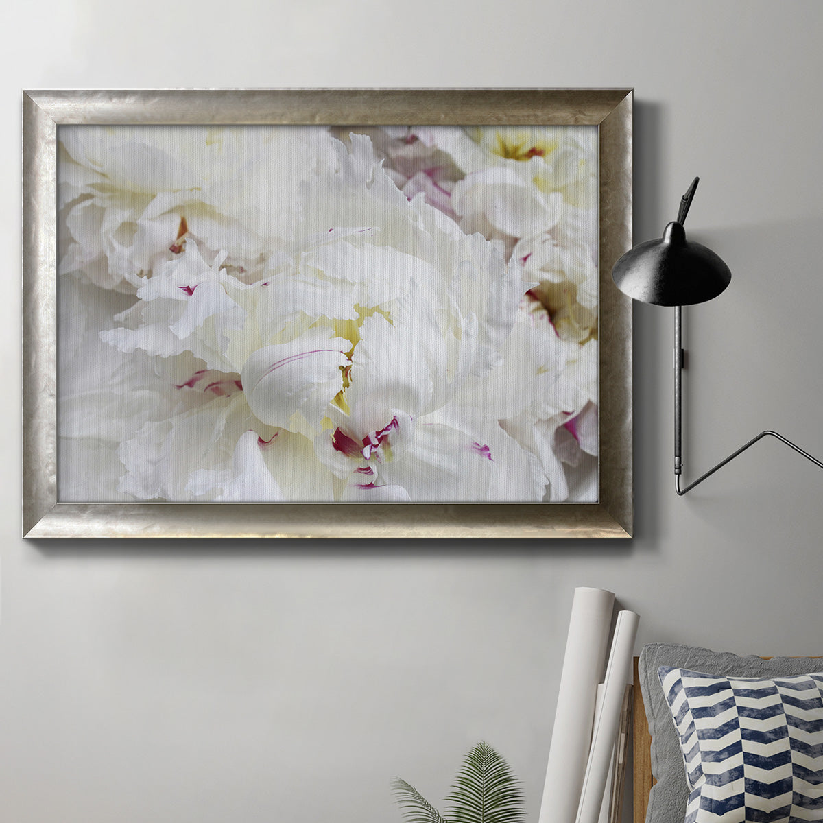 White peonies in bloom in an ornate mottled silver frame displayed in a neutral interior setting.