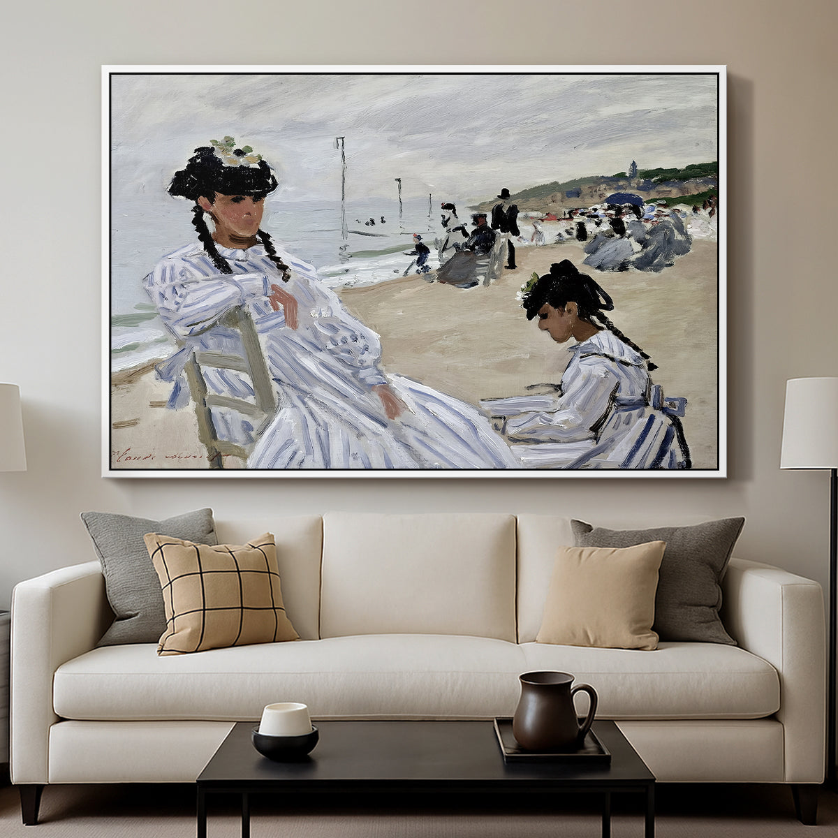 On the Beach at Trouville, 1870 by Claude Monet displayed in a white floater framed canvas above a sofa in a clean living room.