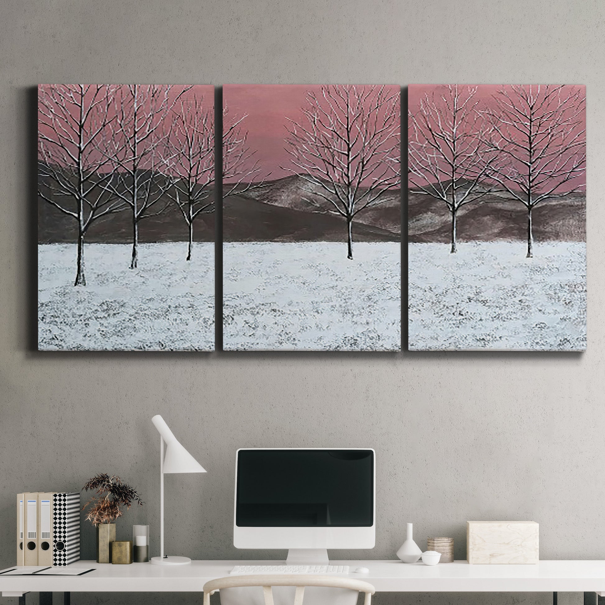 Three-panel canvas wall art featuring winter sunset snowfall landscape, displayed above a desk in a home office.
