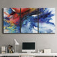 Three-panel canvas wall art featuring vibrant abstract color explosion, displayed above a desk in a home office.