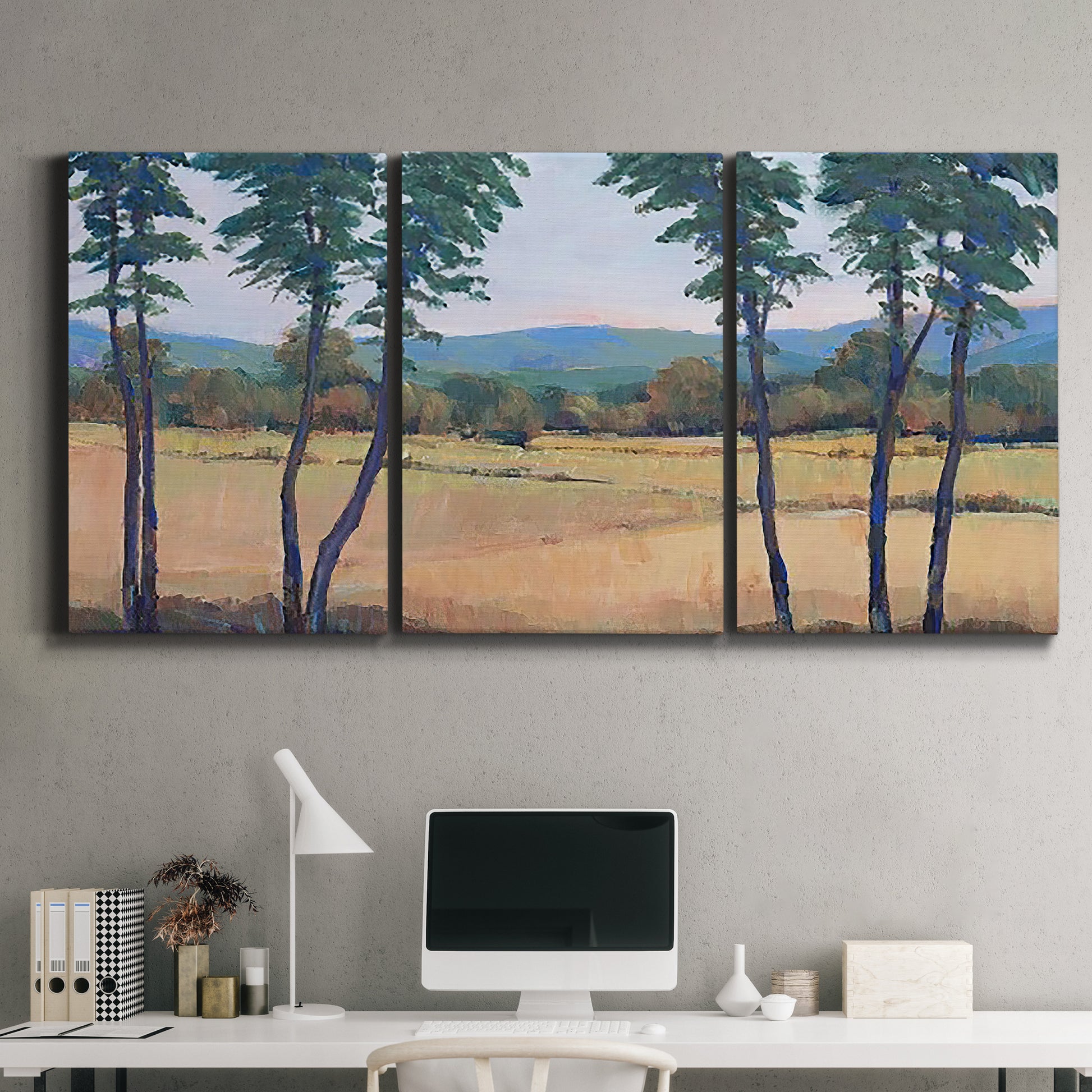 Three-panel canvas wall art featuring quiet morning landscape with trees, displayed above a desk in a home office.