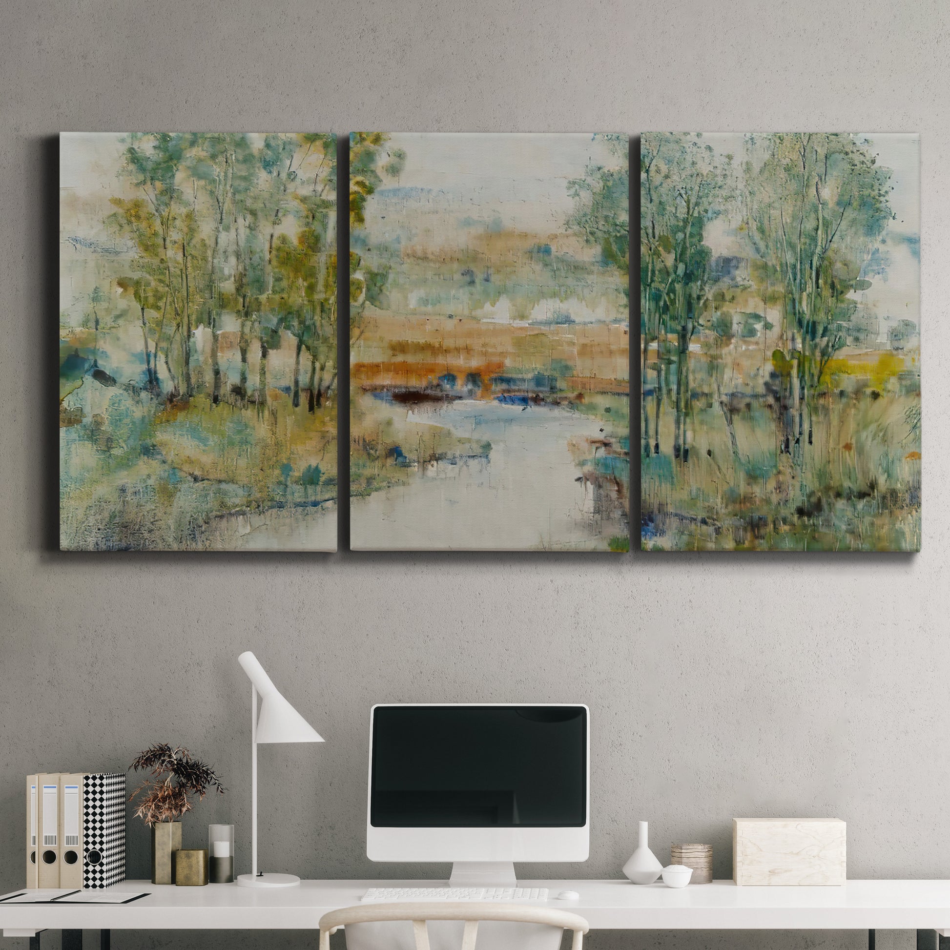 Three-panel canvas wall art featuring trees lining quiet creek, displayed above a desk in a home office.