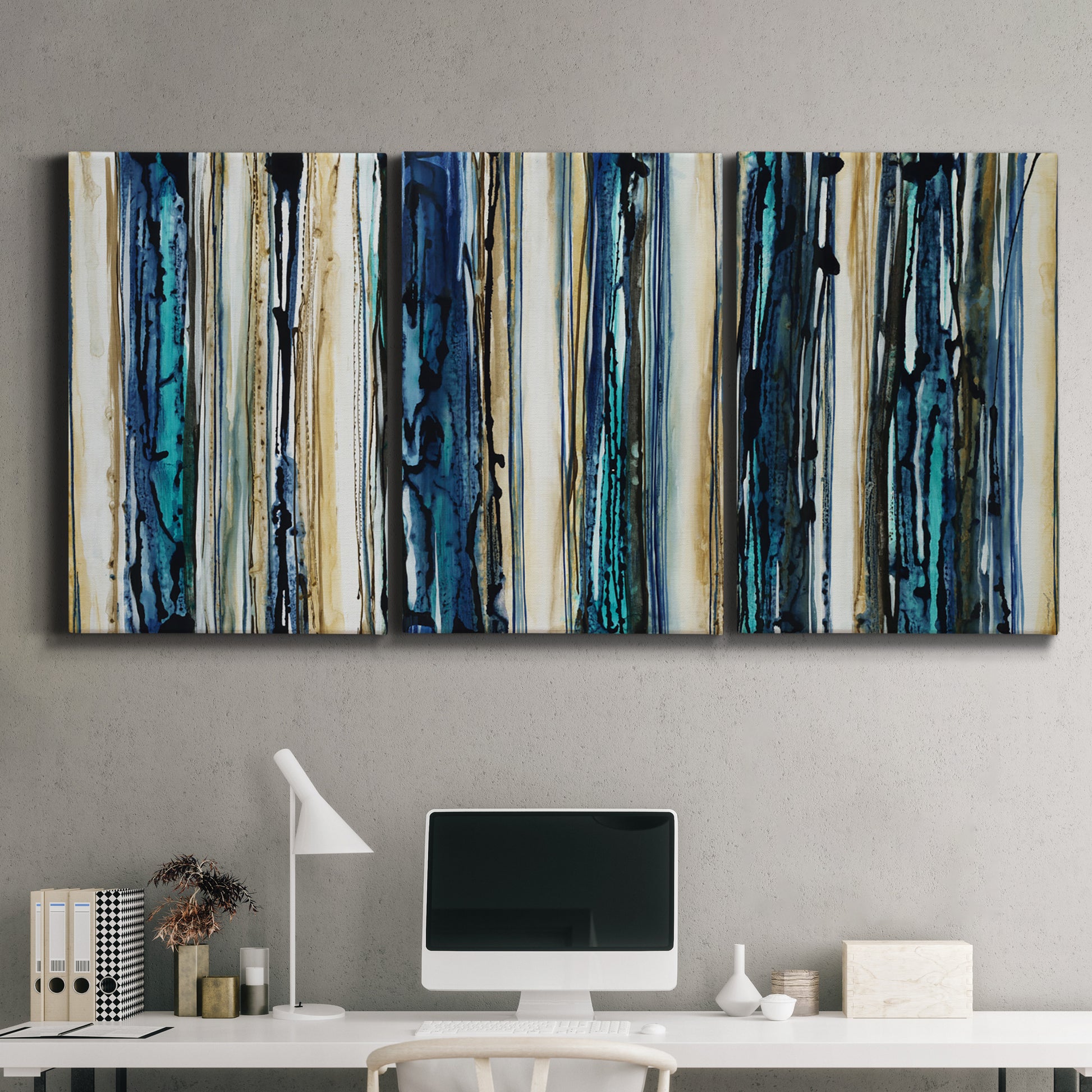 Three-panel canvas wall art featuring vertical blue abstract streaks, displayed above a desk in a home office.