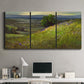 Three-panel canvas wall art featuring winding path through rolling hills, displayed above a desk in a home office.
