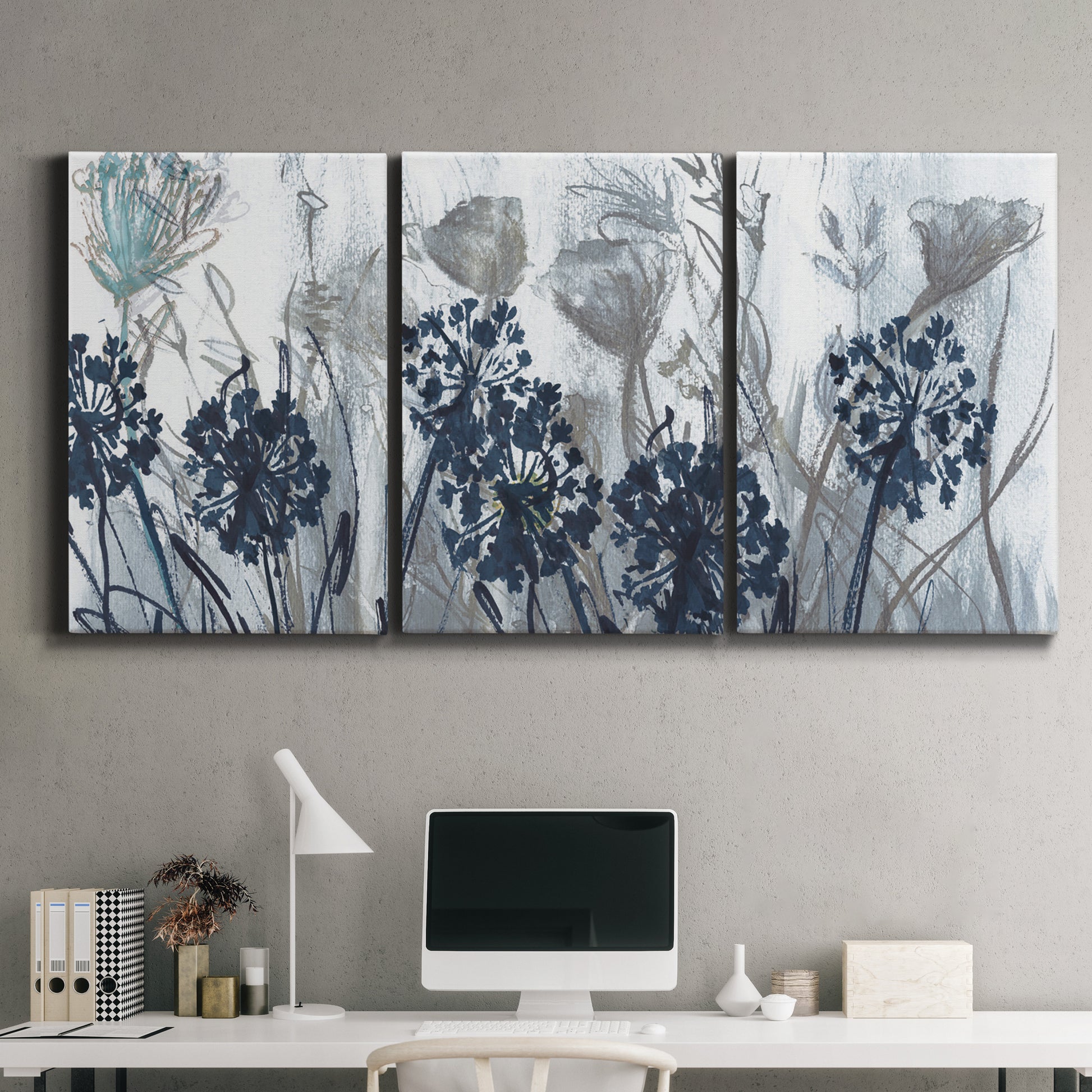 Three-panel canvas wall art featuring indigo floral abstraction, displayed above a desk in a home office.