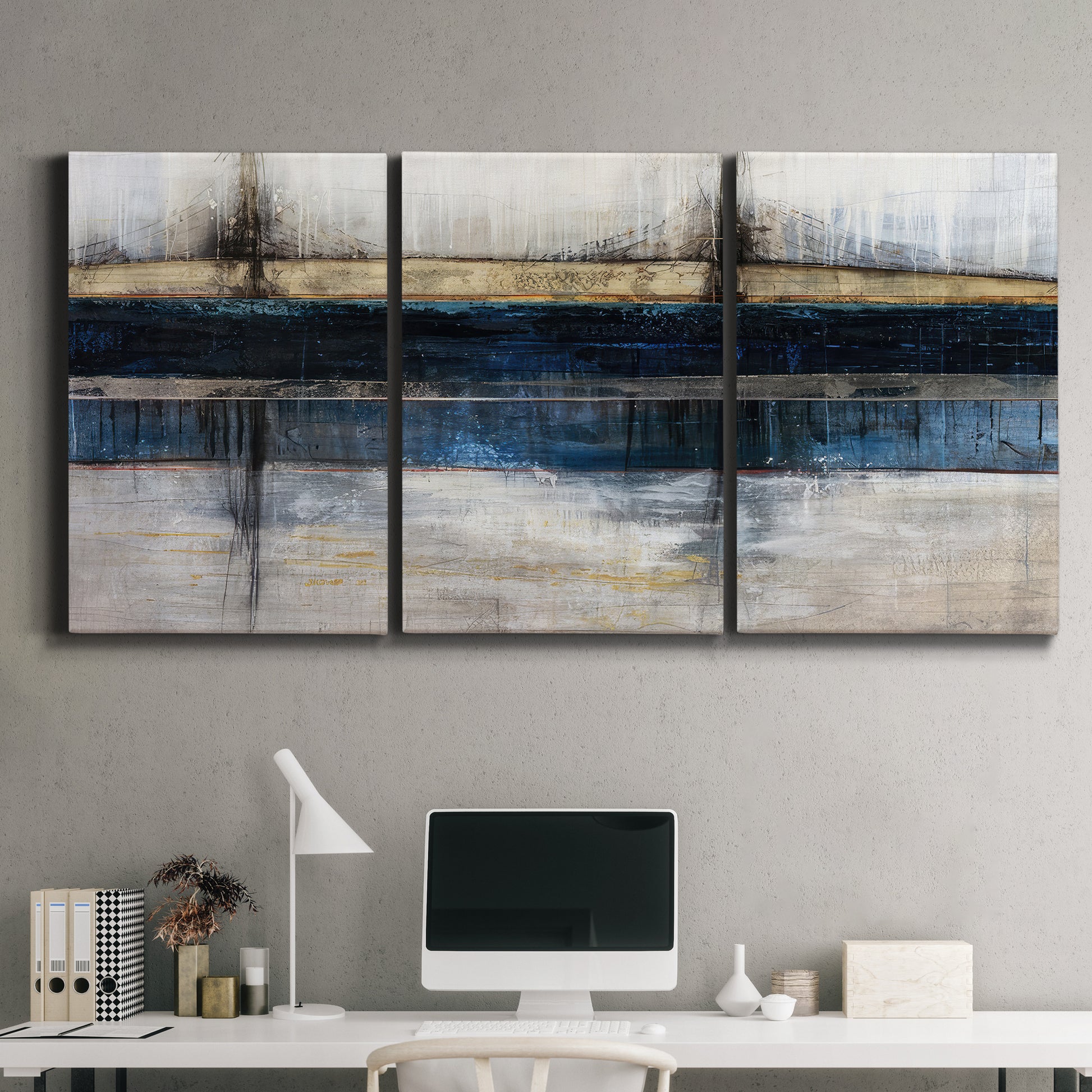 Three-panel canvas wall art featuring abstract blue urban composition, displayed above a desk in a home office.