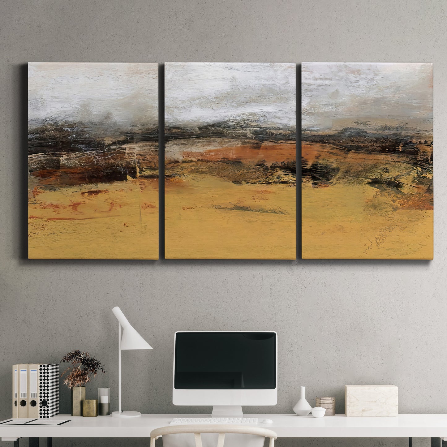 Three-panel canvas wall art featuring abstract bridge landscape in ochre, displayed above a desk in a home office.