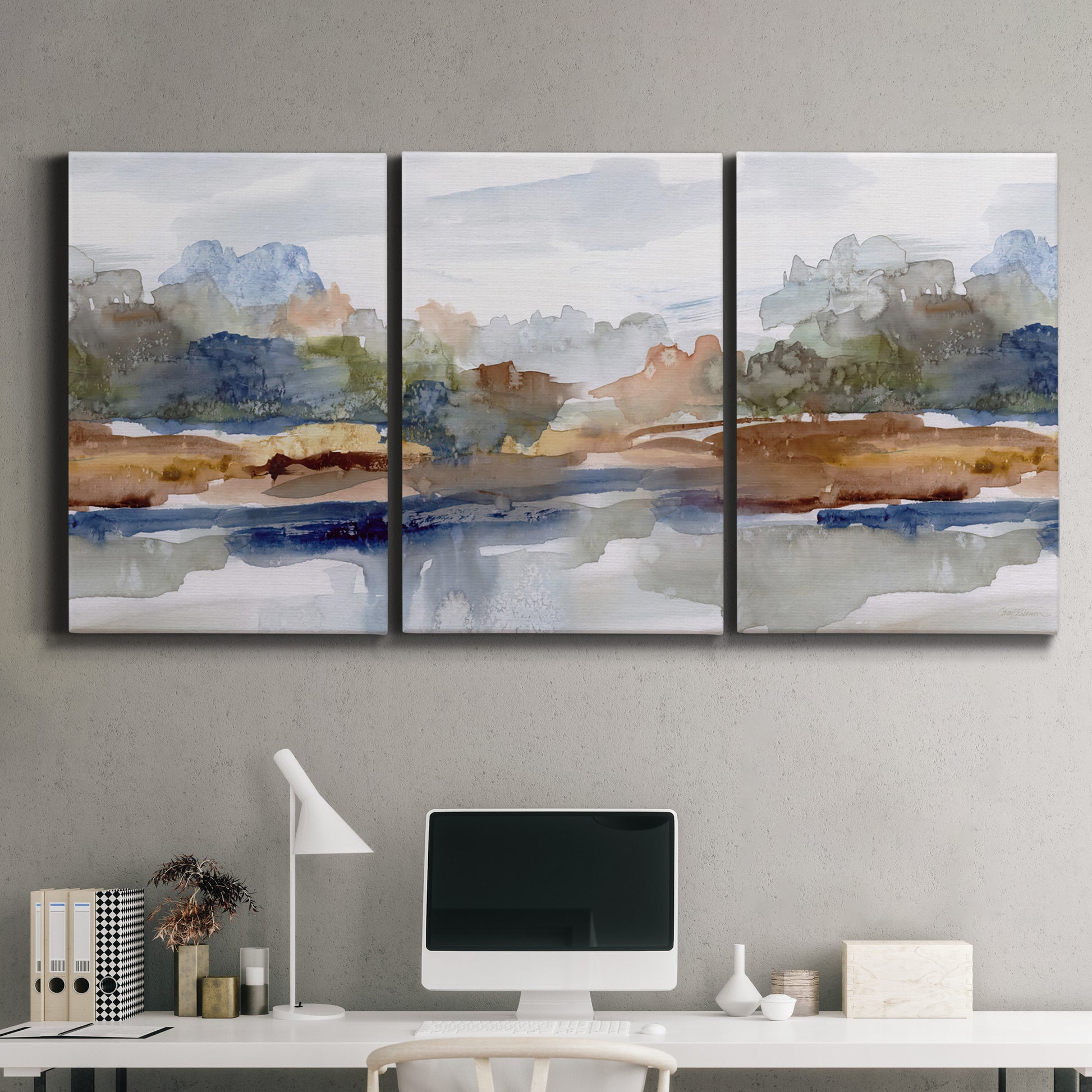 Three-panel canvas wall art featuring layered abstract mountain forms, displayed above a desk in a home office.