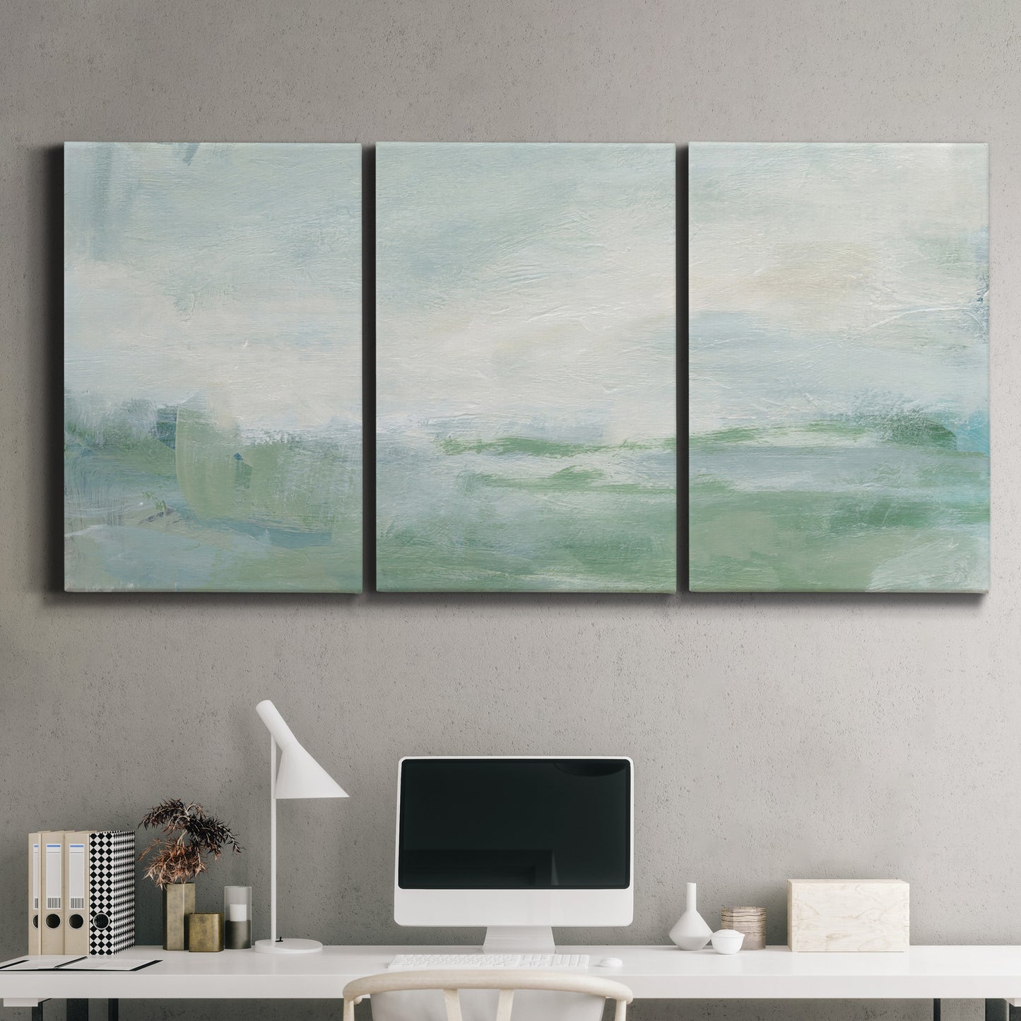 Three-panel canvas wall art featuring soft abstract coastal tones, displayed above a desk in a home office.