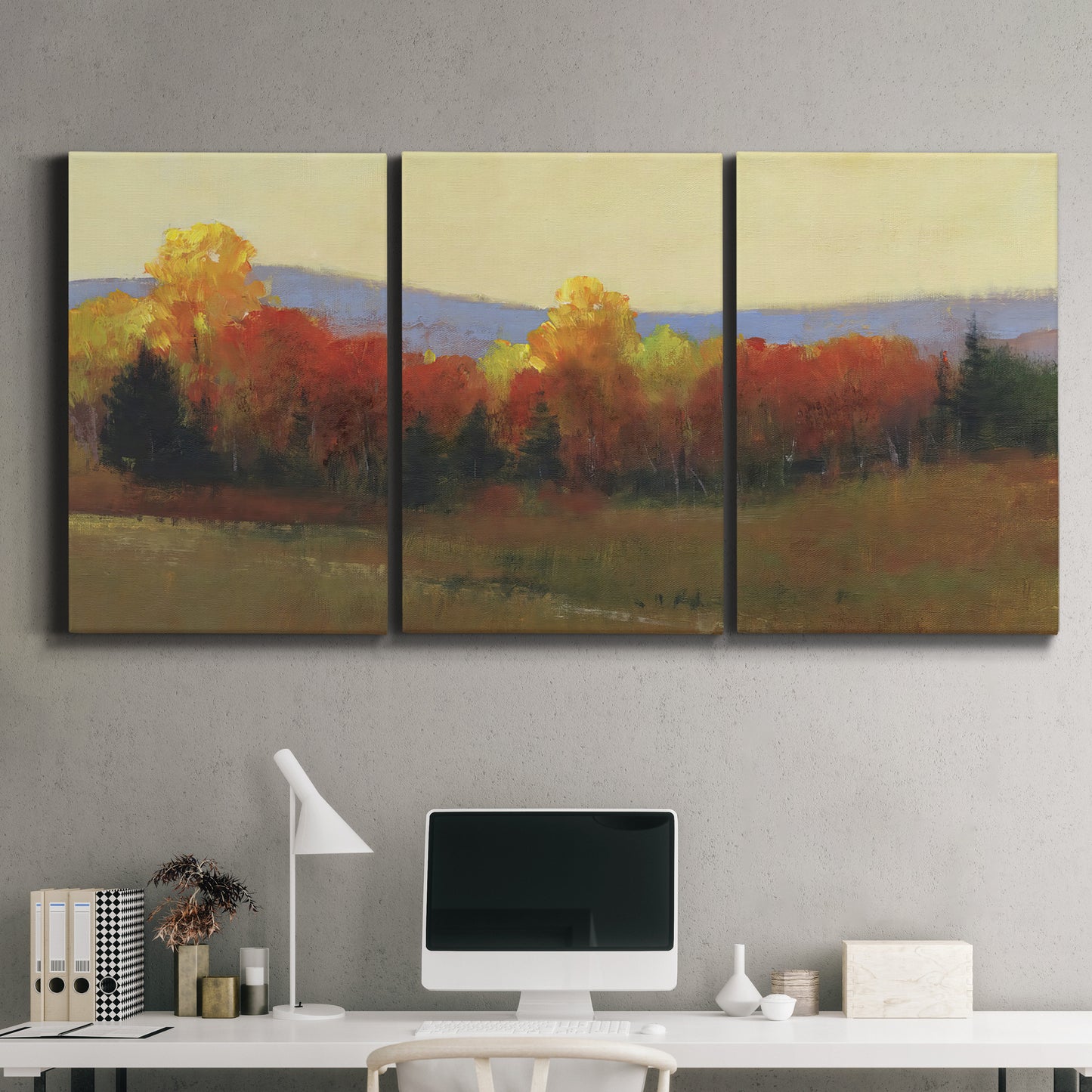 Three-panel canvas wall art featuring autumn landscape changing foliage, displayed above a desk in a home office.