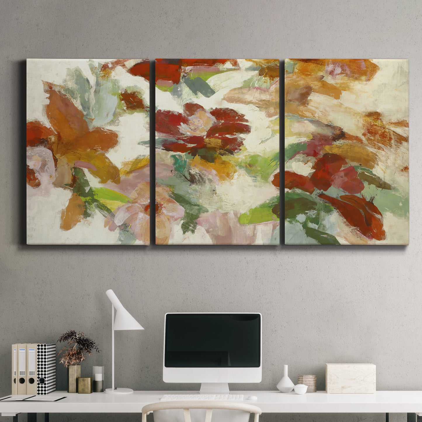 Three-panel canvas wall art featuring layered floral botanical impressions, displayed above a desk in a home office.