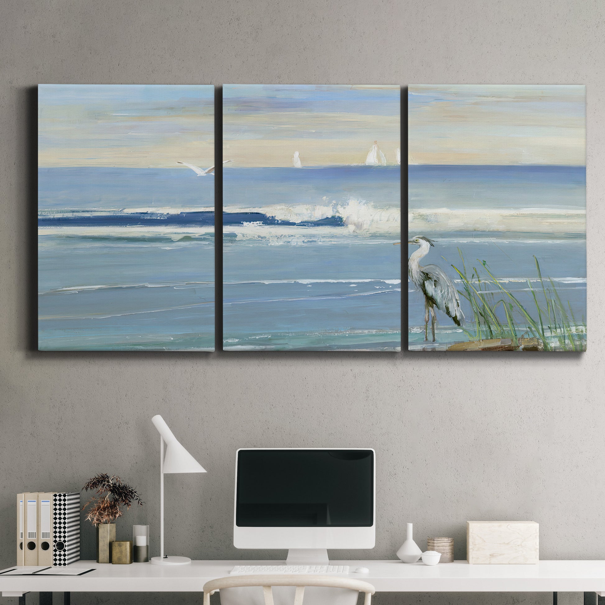 Three-panel canvas wall art featuring sunrise reflecting across bay waters, displayed above a desk in a home office.