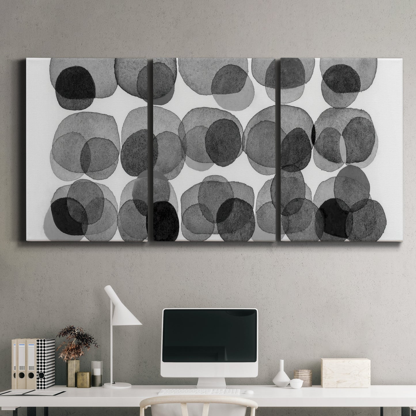 Three-panel canvas wall art featuring geometric abstract watercolor forms, displayed above a desk in a home office.