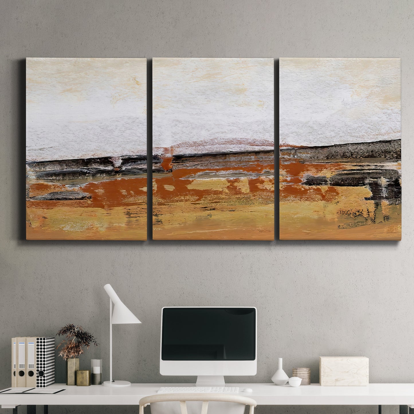 Three-panel canvas wall art featuring abstract bridge landscape in ochre, displayed above a desk in a home office.