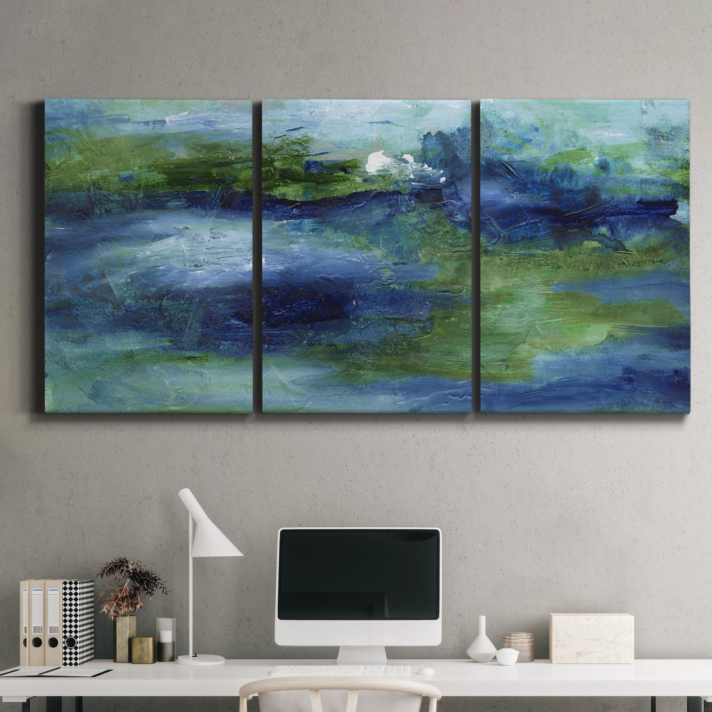 Three-panel canvas wall art featuring flowing blue abstract watercolor, displayed above a desk in a home office.