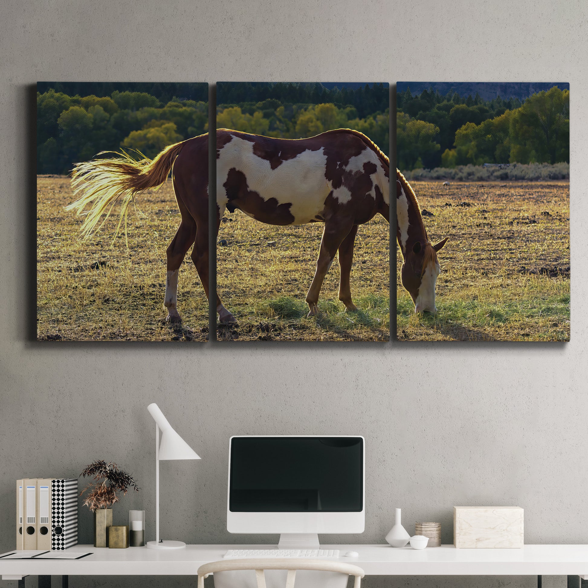 Three-panel canvas wall art featuring horses standing near farmhouse, displayed above a desk in a home office.