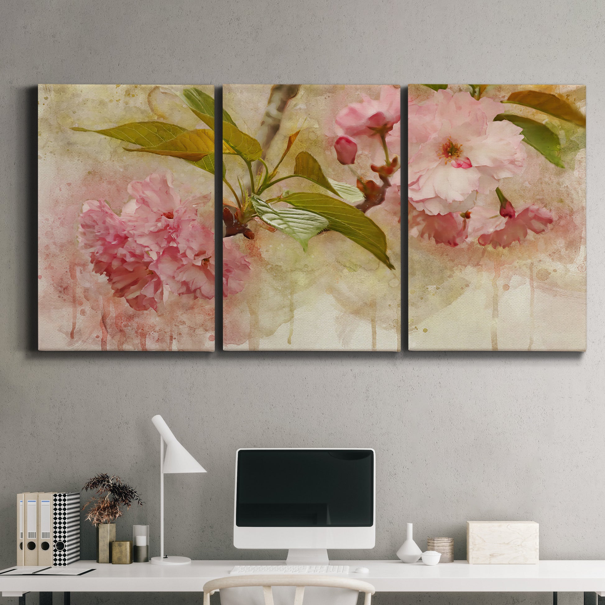 Three-panel canvas wall art featuring soft floral blossom composition, displayed above a desk in a home office.