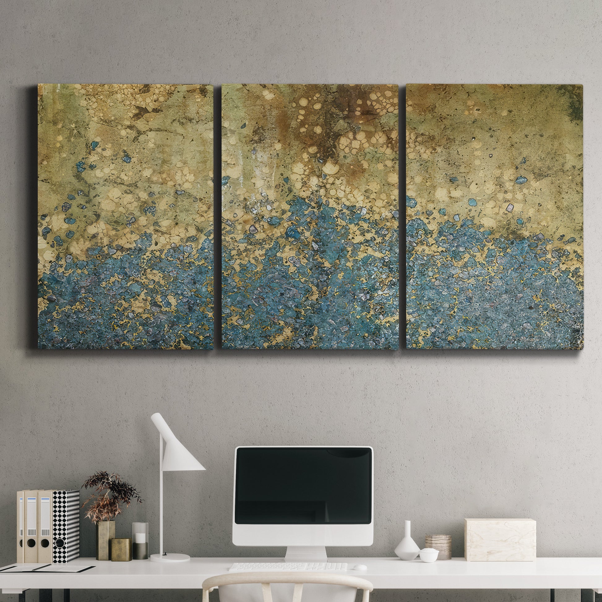 Three-panel canvas wall art featuring metallic abstract gold tones, displayed above a desk in a home office.