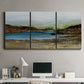 Three-panel canvas wall art featuring peaceful lakeside shoreline landscape, displayed above a desk in a home office.