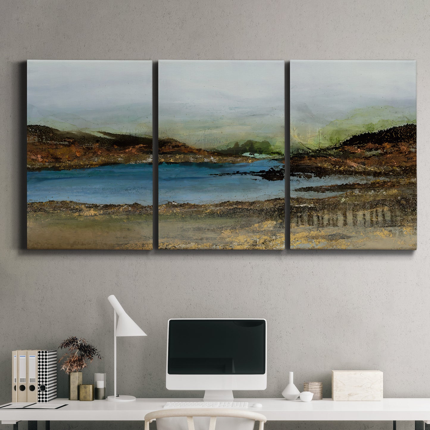 Three-panel canvas wall art featuring peaceful lakeside shoreline landscape, displayed above a desk in a home office.