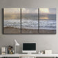 Three-panel canvas wall art featuring calm coastal shoreline seascape, displayed above a desk in a home office.