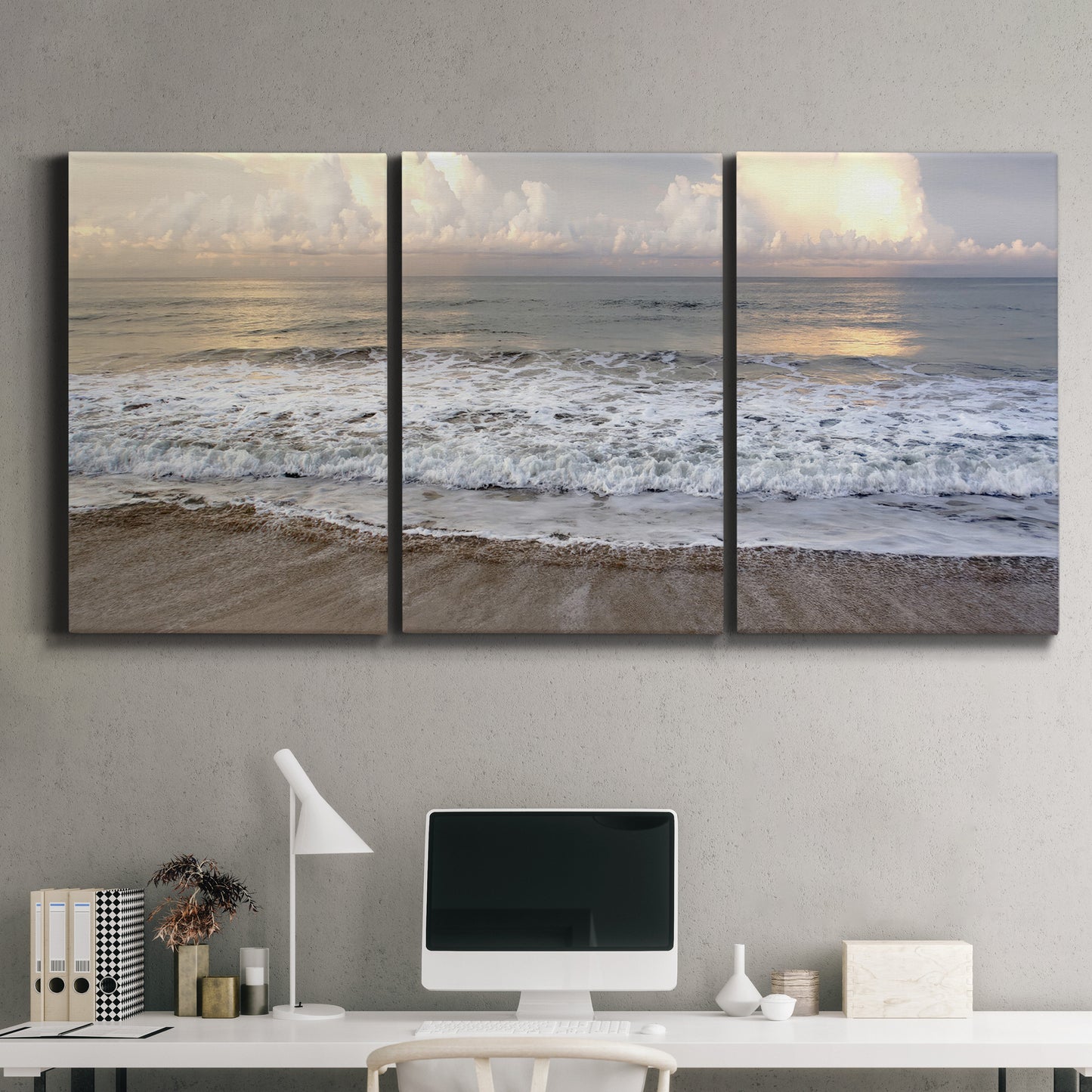 Three-panel canvas wall art featuring calm coastal shoreline seascape, displayed above a desk in a home office.