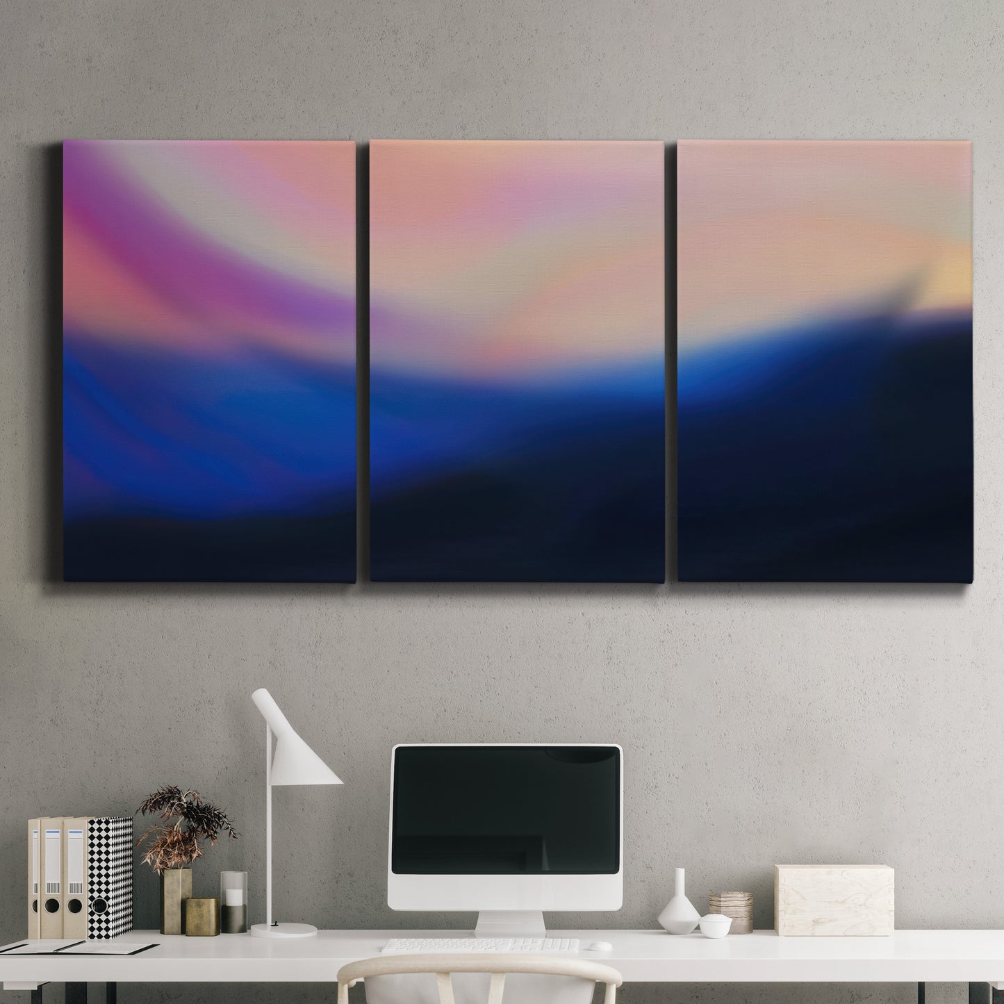 Three-panel canvas wall art featuring smooth abstract sunset color gradient, displayed above a desk in a home office.