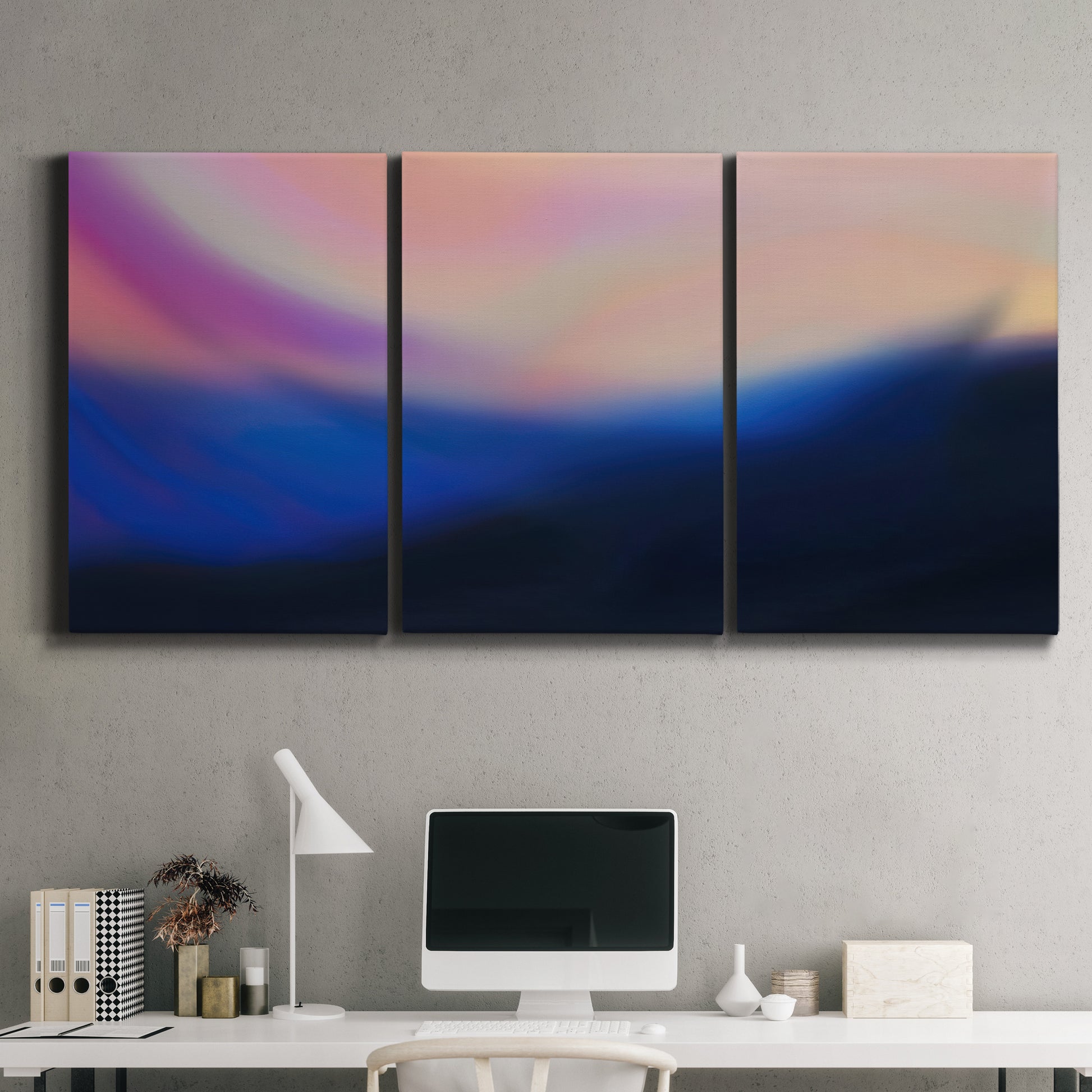 Three-panel canvas wall art featuring smooth abstract sunset color gradient, displayed above a desk in a home office.