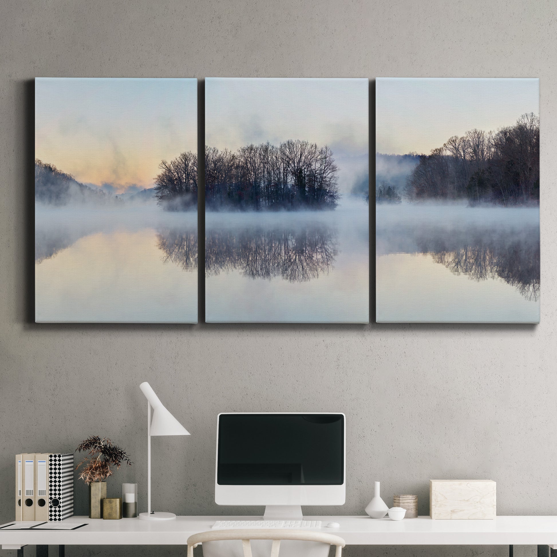 Three-panel canvas wall art featuring misty water landscape photograph, displayed above a desk in a home office.