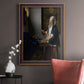 Quiet interior genre scene of a woman with scales by Johannes Vermeer in an ornate bronzed mahogany wood frame displayed in a neutral interior setting.