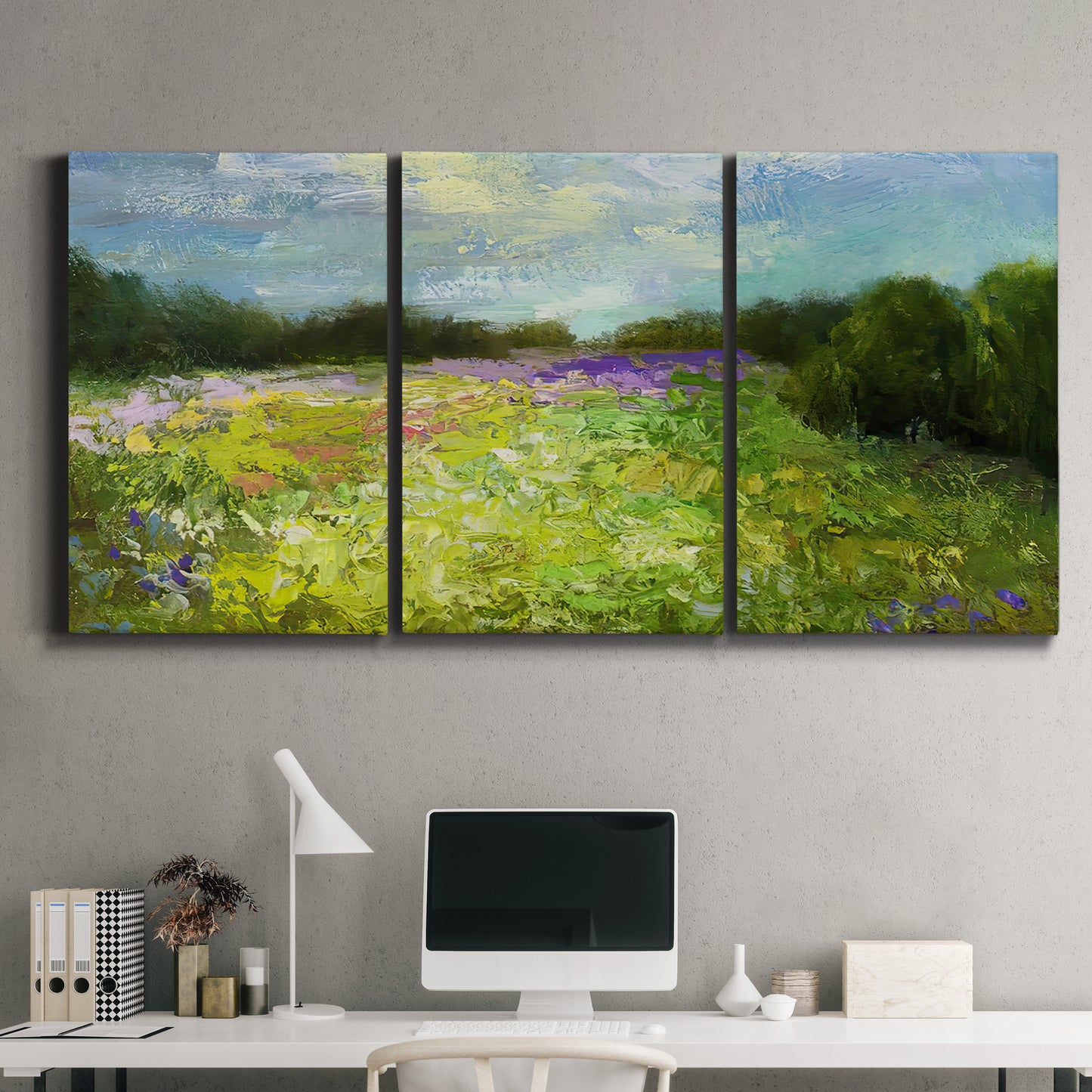 Three-panel canvas wall art featuring pastoral field with wildflowers, displayed above a desk in a home office.