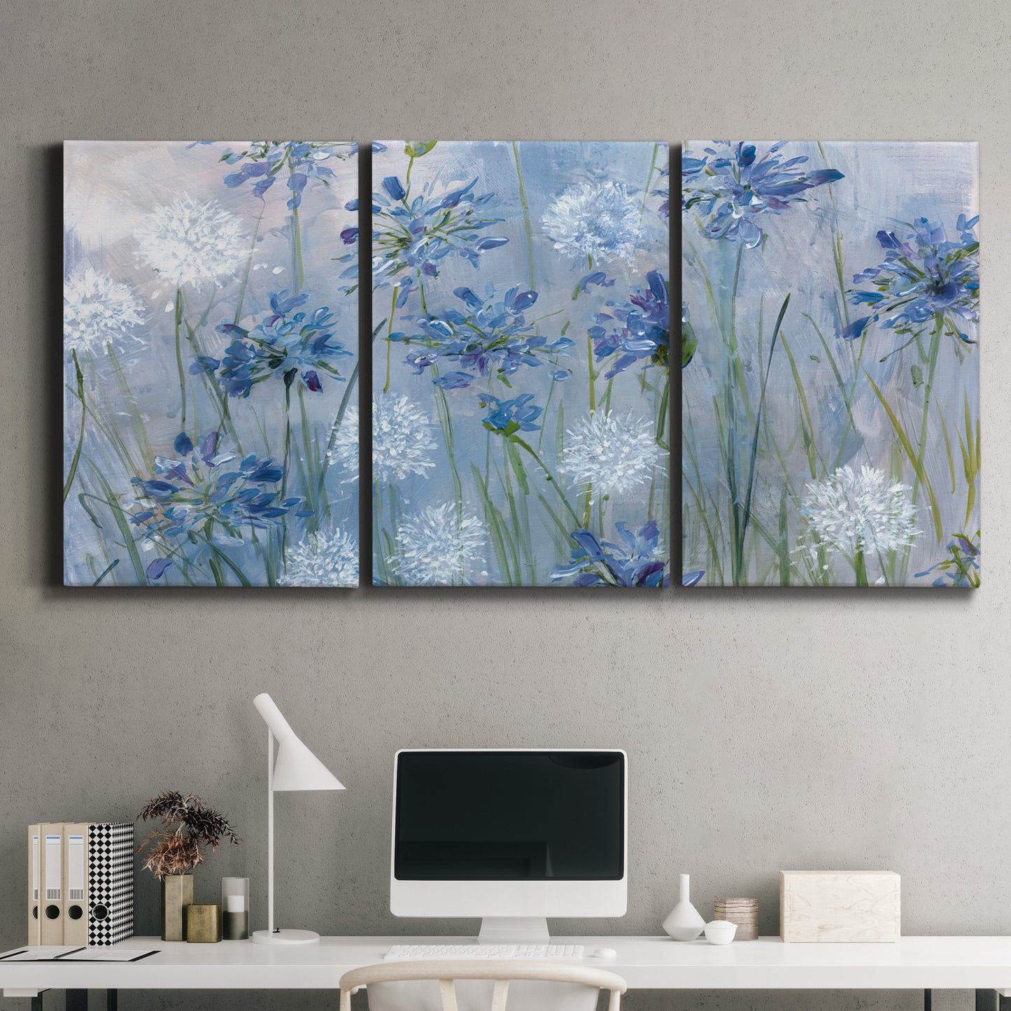 Three-panel canvas wall art featuring delicate watercolor floral blooms, displayed above a desk in a home office.