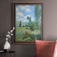 Impressionist pastoral landscape with poppy fields by Claude Monet in an ornate bronzed mahogany wood frame displayed in a neutral interior setting.