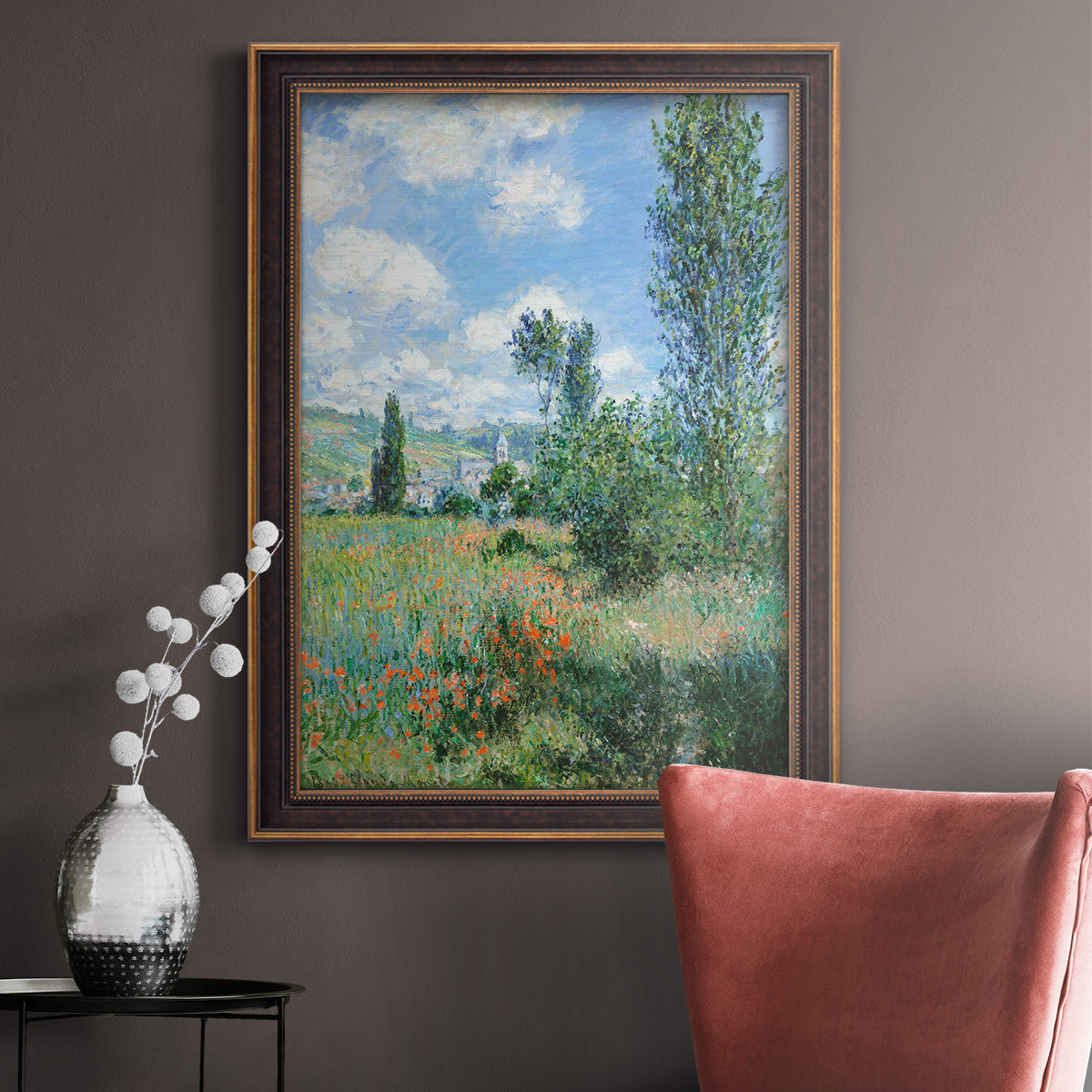 Impressionist pastoral landscape with poppy fields by Claude Monet in an ornate bronzed mahogany wood frame displayed in a neutral interior setting.
