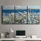 Three-panel canvas wall art featuring coastal garden overlooking bay, displayed above a desk in a home office.