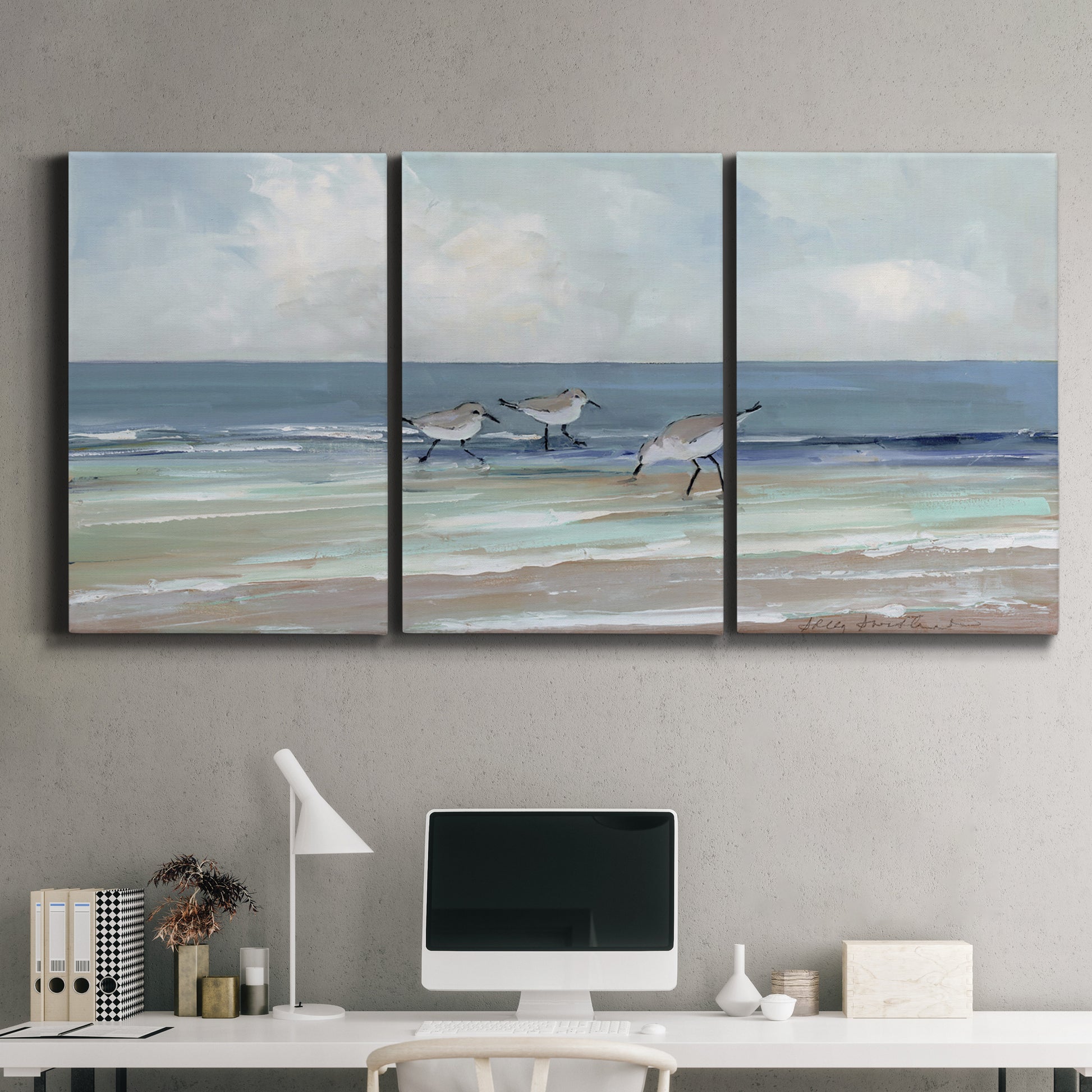 Three-panel canvas wall art featuring shore birds searching along beach, displayed above a desk in a home office.