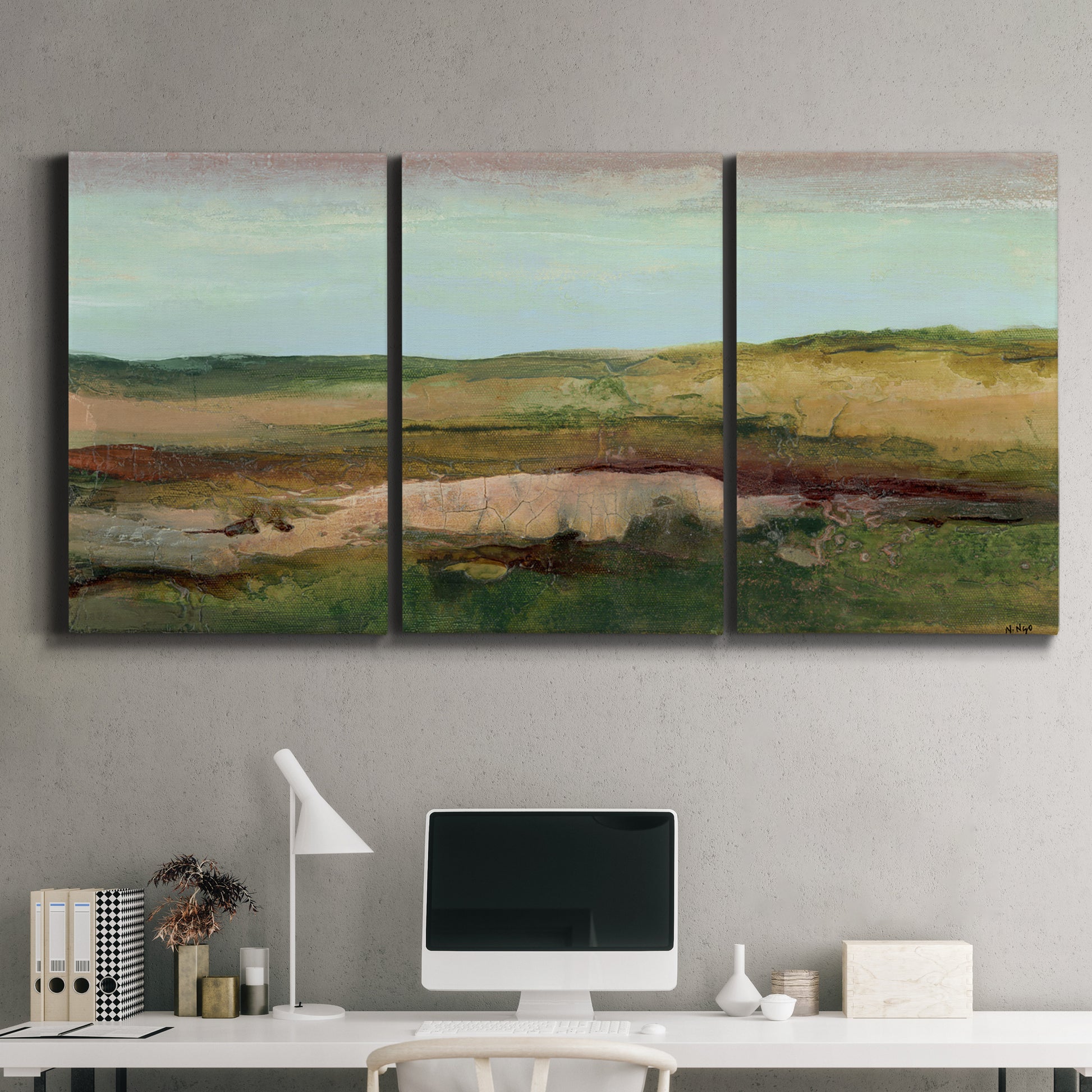 Three-panel canvas wall art featuring pastoral landscape with winding road, displayed above a desk in a home office.