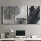 Three-panel canvas wall art featuring dark abstract atmospheric landscape, displayed above a desk in a home office.
