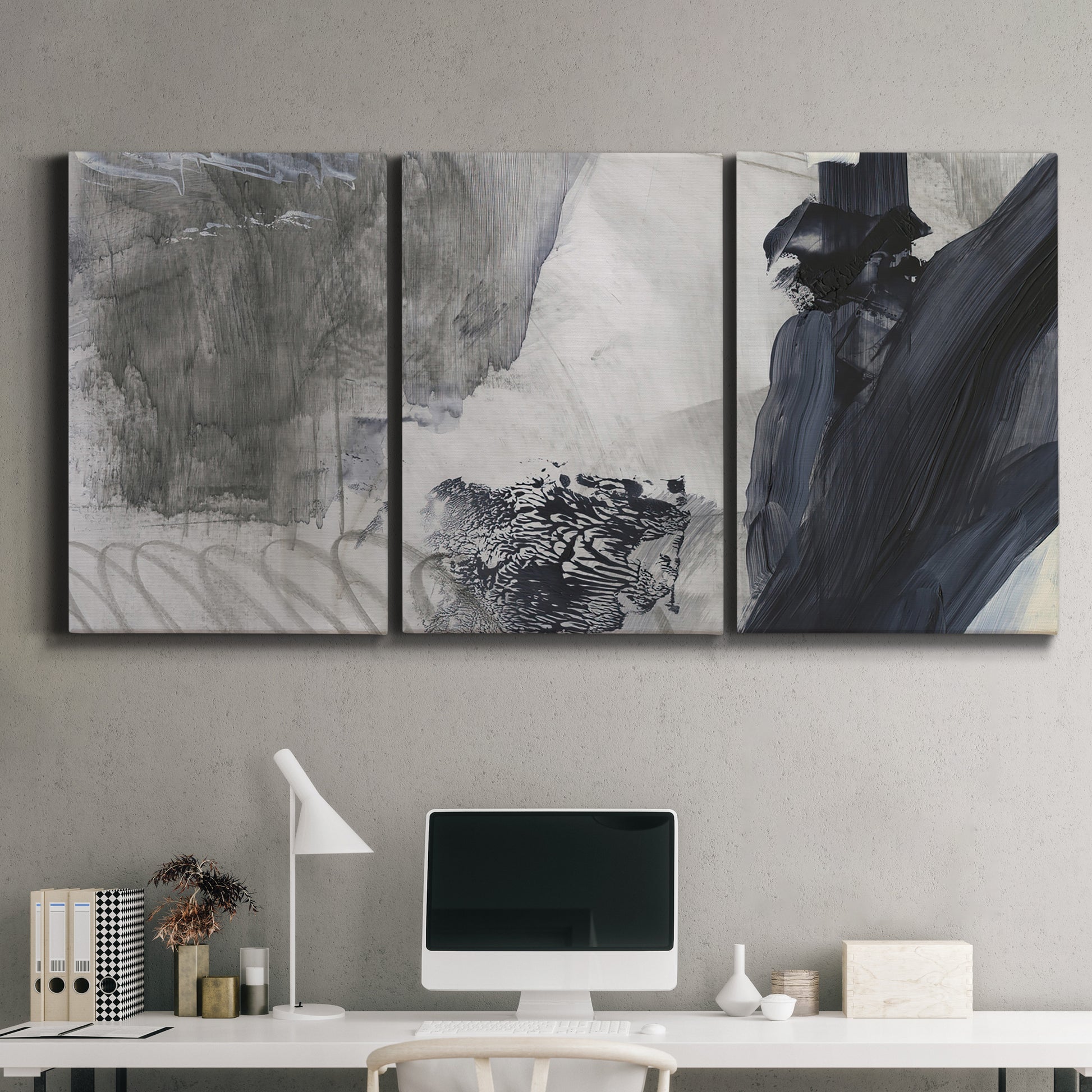 Three-panel canvas wall art featuring dark abstract atmospheric landscape, displayed above a desk in a home office.