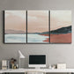 Three-panel canvas wall art featuring quiet coastline with distant horizon, displayed above a desk in a home office.