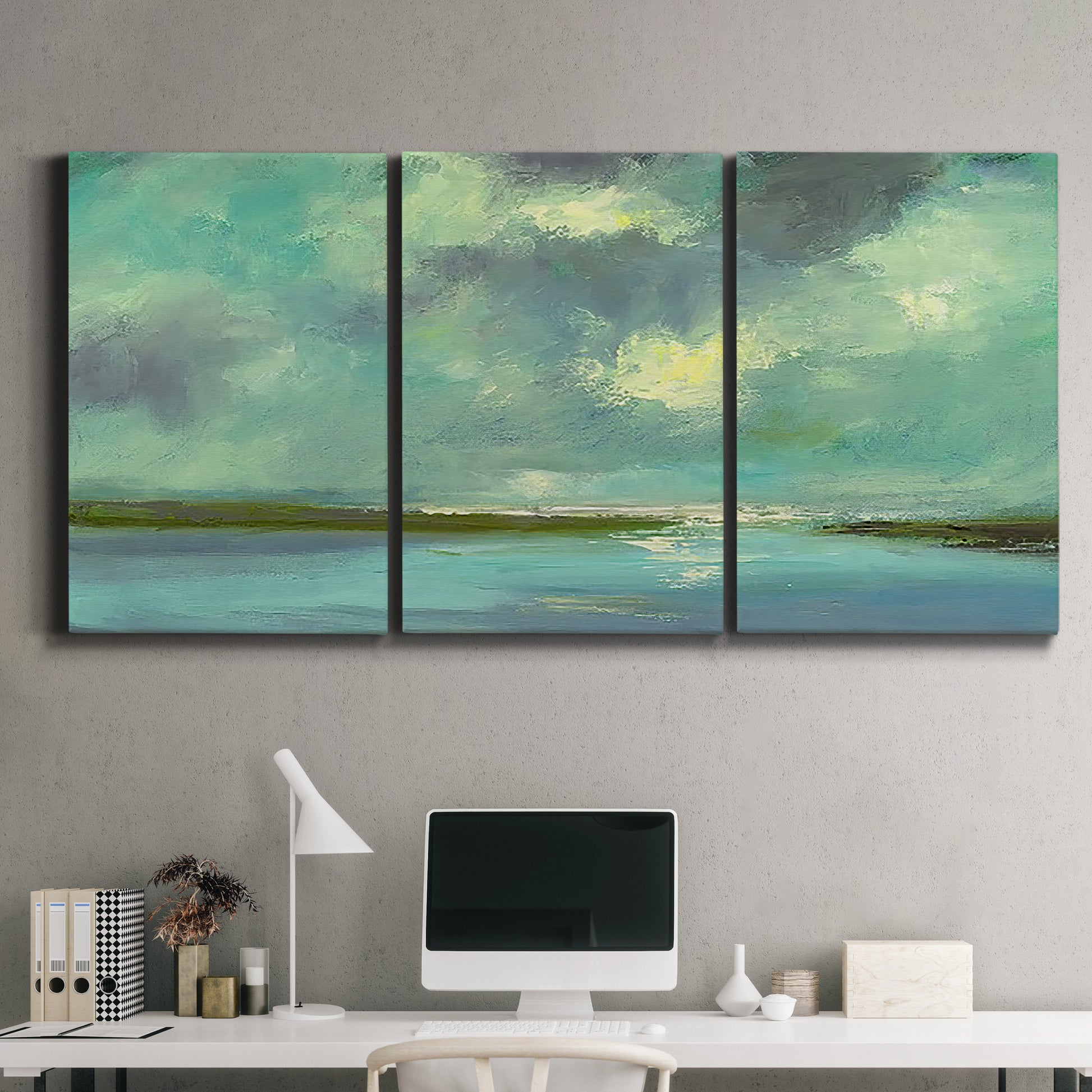 Three-panel canvas wall art featuring still lagoon water beneath open sky, displayed above a desk in a home office.