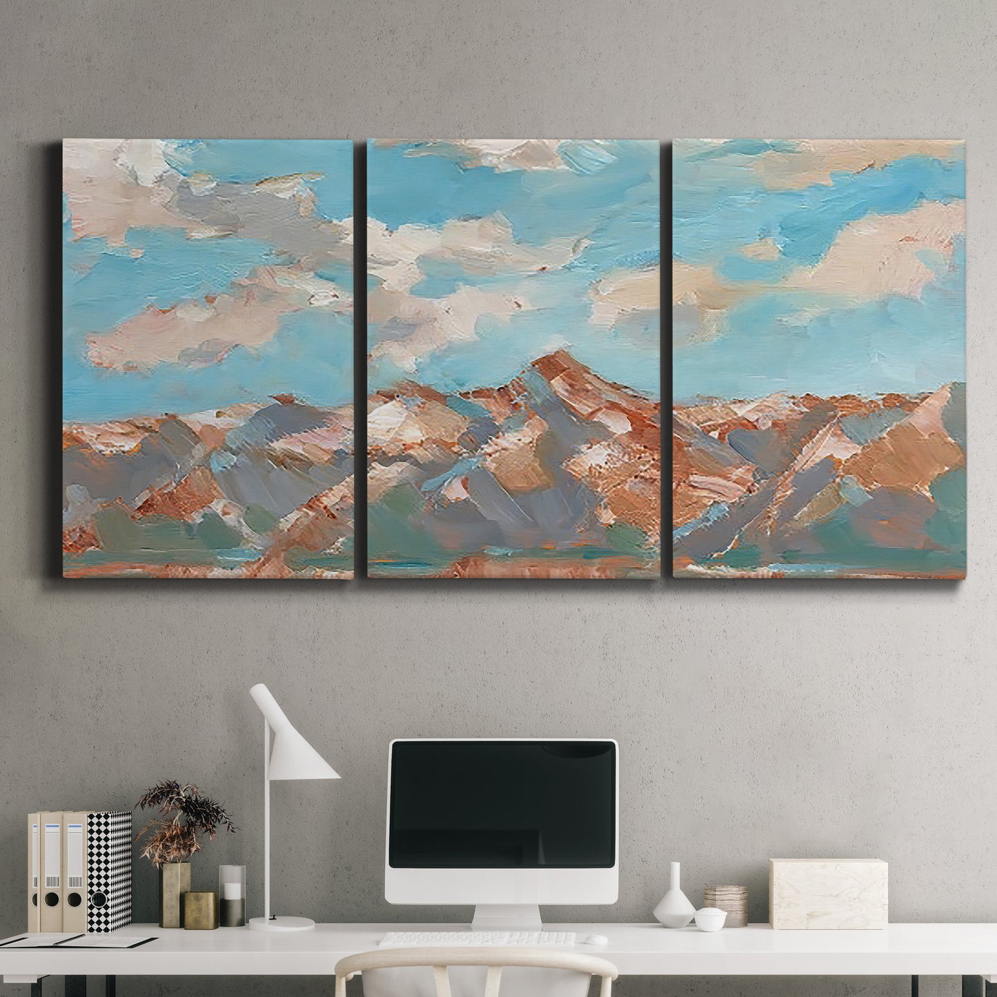 Three-panel canvas wall art featuring soft pastel western hills landscape, displayed above a desk in a home office.