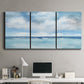 Three-panel canvas wall art featuring tropical clouds over ocean horizon, displayed above a desk in a home office.