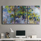 Three-panel canvas wall art featuring cascading purple wisteria blooms, displayed above a desk in a home office.