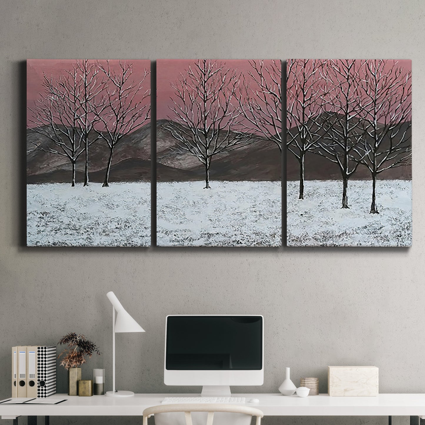 Three-panel canvas wall art featuring winter sunset snowfall landscape, displayed above a desk in a home office.
