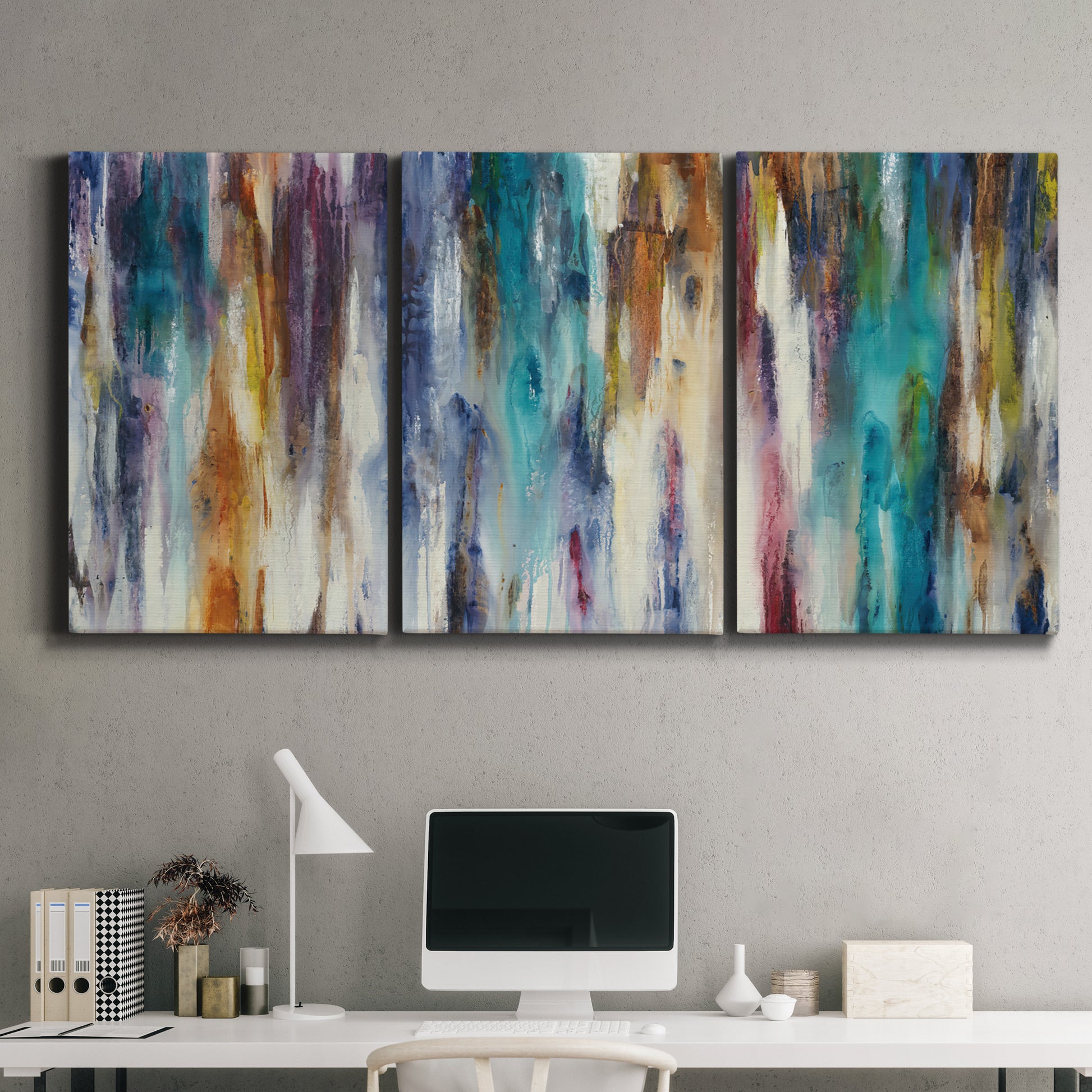 Three-panel canvas wall art featuring abstract shifting color forms, displayed above a desk in a home office.