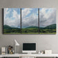 Three-panel canvas wall art featuring pastoral mountain landscape in blue, displayed above a desk in a home office.
