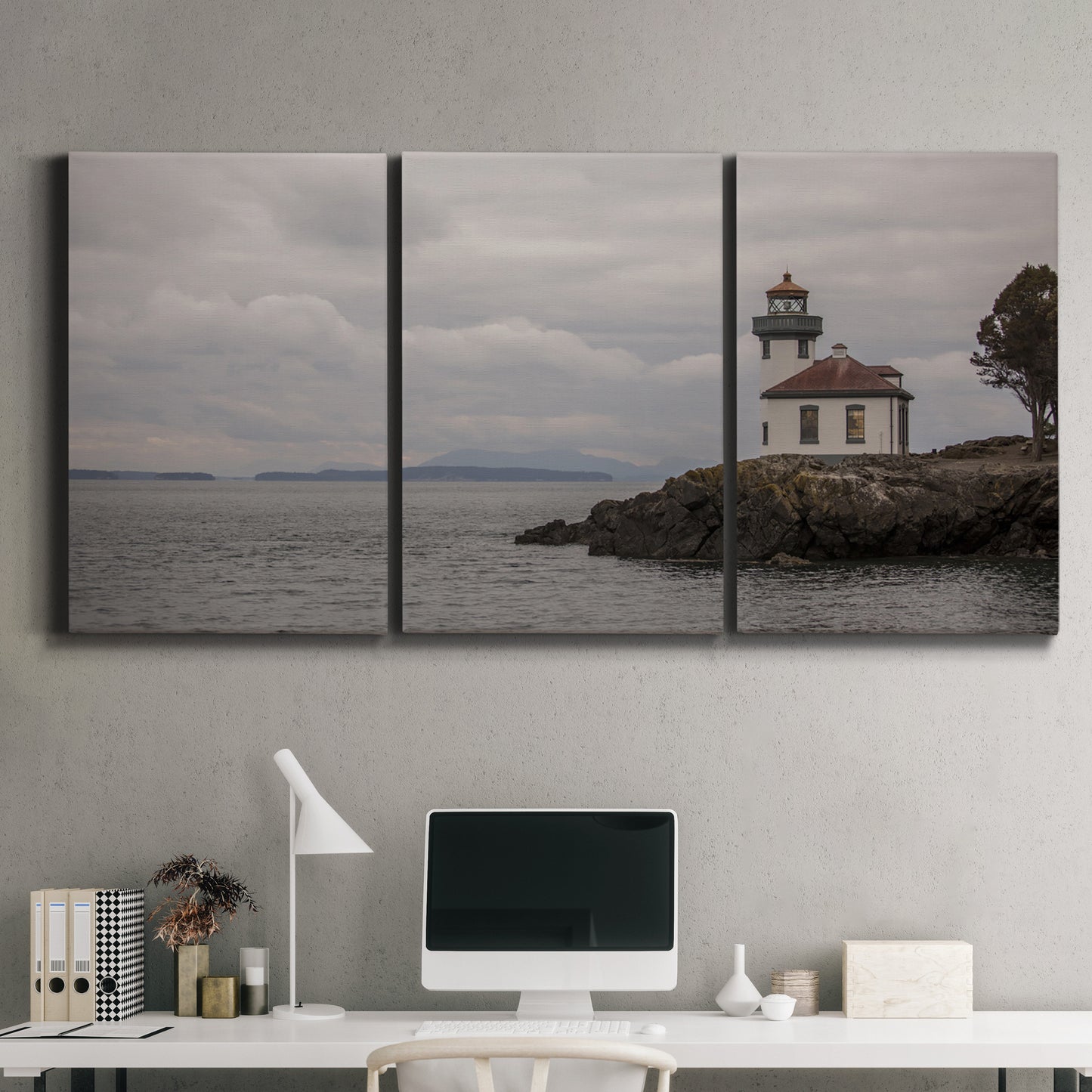 Three-panel canvas wall art featuring lighthouse watching over coastline, displayed above a desk in a home office.